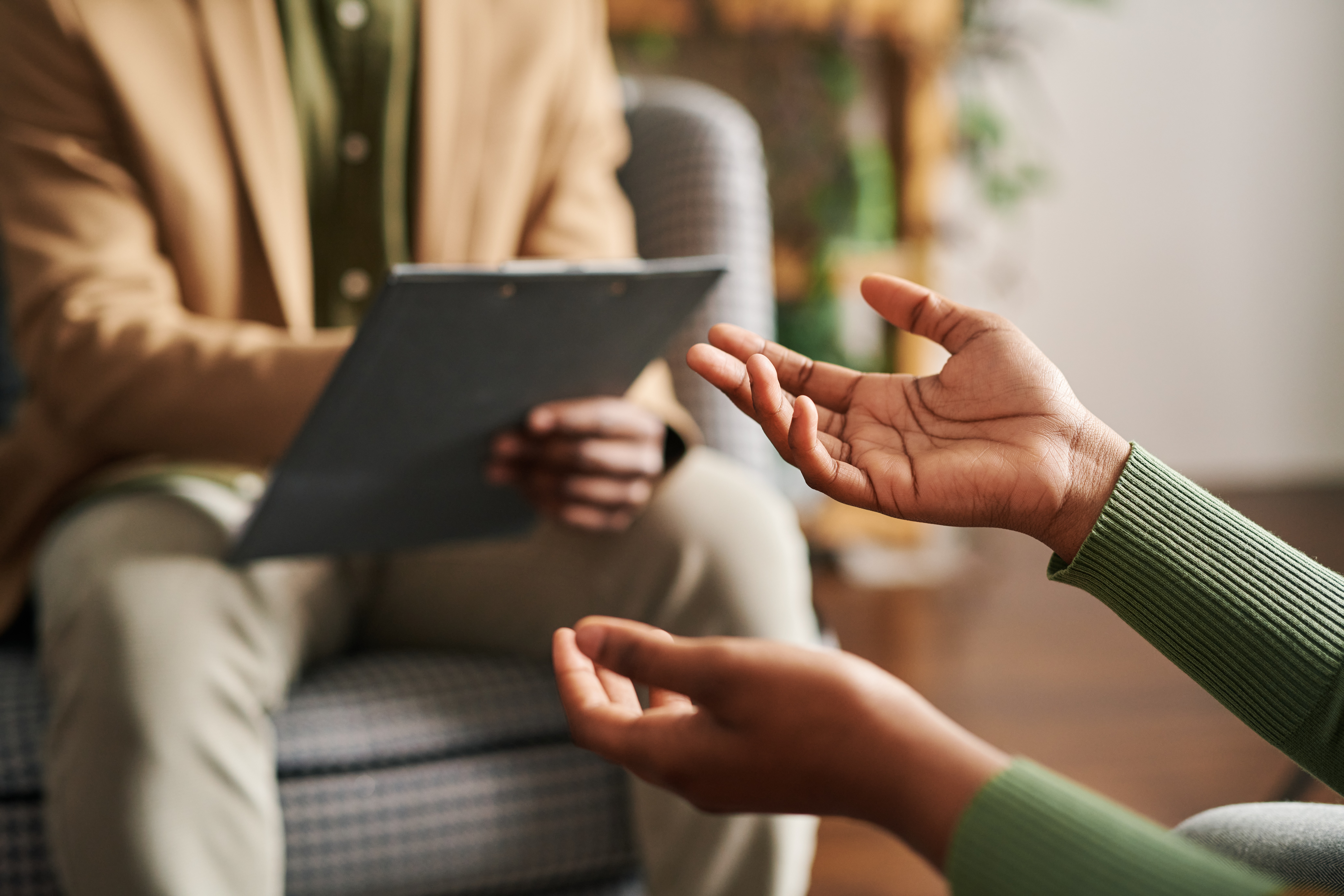 Individual with a clipboard talking with another individual in a provider setting by getty-images